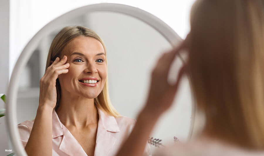 mature woman looking at herself in the mirror