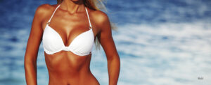 Female in white bikini by the beach